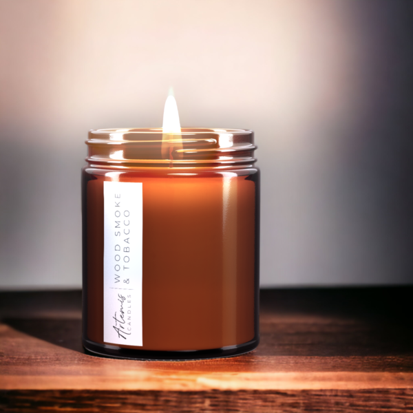 Artemis Candle Company Branded Soy Wax Wood Smoke and Tobacco Scented Candle Shown In Amber Glass Jar