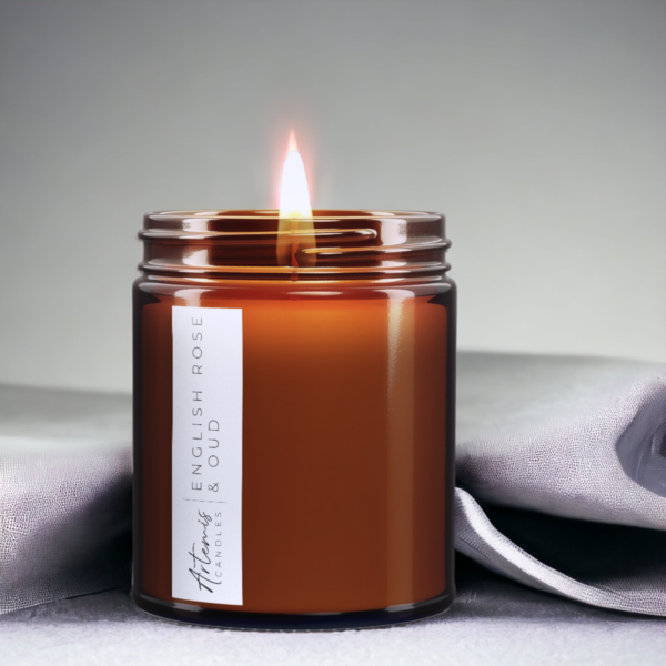 Artemis Candle Company Branded Soy Wax English Oak and Oud Scented Candle Shown In Amber Glass Jar